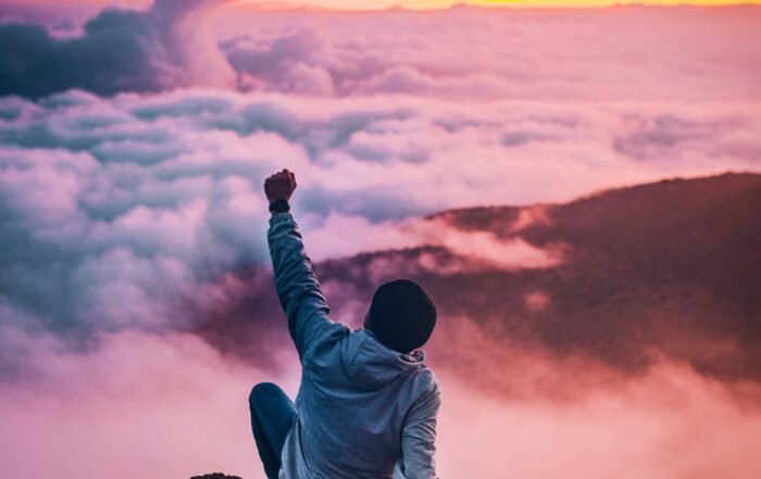 Man with fist raised to welcome the sunrise